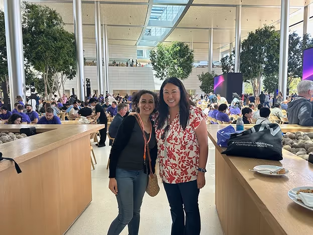 햇살 가득한 Apple Park 아트리움에서 Apple 여성 네트워크의 한 여성과 함께 포즈를 취한 Sylvia Said